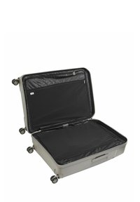 Maleta gris de concha dura con cuatro ruedas, abierta para revelar un interior negro y un bolsillo con cremallera. Textura suave, forma rectangular, diseñada para viajar.