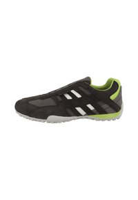 Scarpa atletica nera in suede con una tomaia in mesh traspirante, accenti verdi, strisce bianche e suola in gomma flessibile.