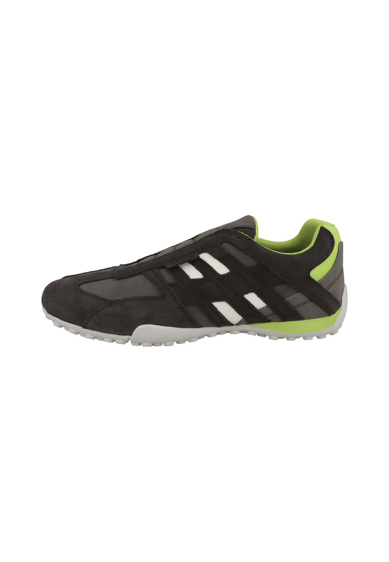Scarpa atletica nera in suede con una tomaia in mesh traspirante, accenti verdi, strisce bianche e suola in gomma flessibile.