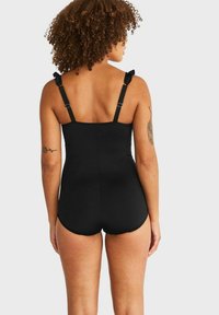 Svart baddräkt i ett stycke med justerbara axelremmar, slät tyg, åtsittande design och måttlig benöppning. Inkluderar en bekväm rygg.