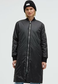 Black long-line bomber jacket made of glossy, lightweight material with a front zipper, side pockets, and ribbed cuffs.