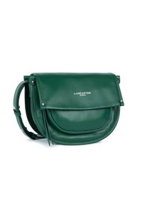 Borsa a tracolla in pelle verde Lancaster Paris con chiusura a pattina e tracolla regolabile su sfondo bianco.