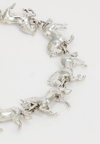 Ezüst fém karkötő, amely több vágtázó ló charmot tartalmaz, részletes sörény- és farokdíszítéssel, kis láncszemekkel összekötve.