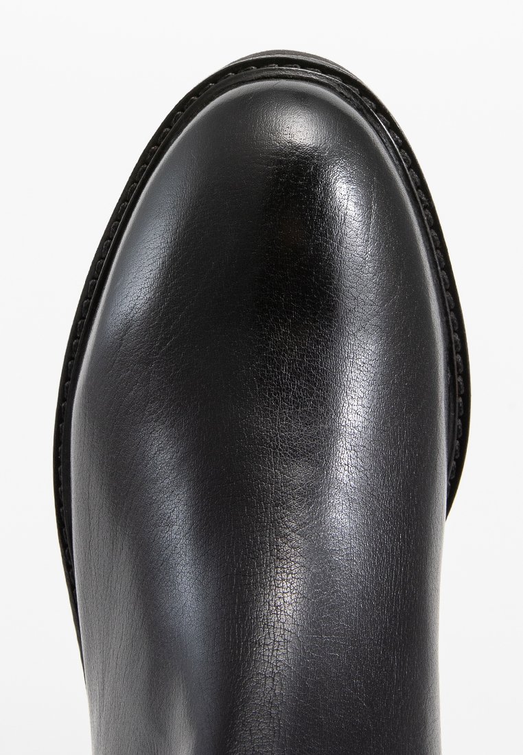 Zwarte leren laars met een glanzende afwerking, ronde neus en gestikte randen. Gladde textuur met een stevige zool en minimale detailing.