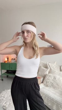 Ljusrosa tygdiadem som bärs med en vit linne och svarta byxor med vida ben. Mjuk textur och enkel design som kompletterar utseendet.