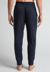 Marineblauwe joggingsbroek van zachte stof, met een relaxed fit, een elastische tailleband en taps toelopende enkels met ribbelmanchetten.