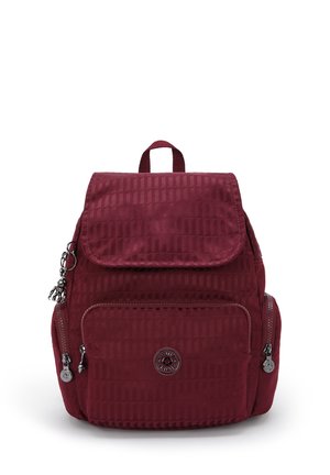 Maroon backpack with a textured surface, flap closure, front zipper pocket, and logo detail. Features adjustable straps and a top handle.