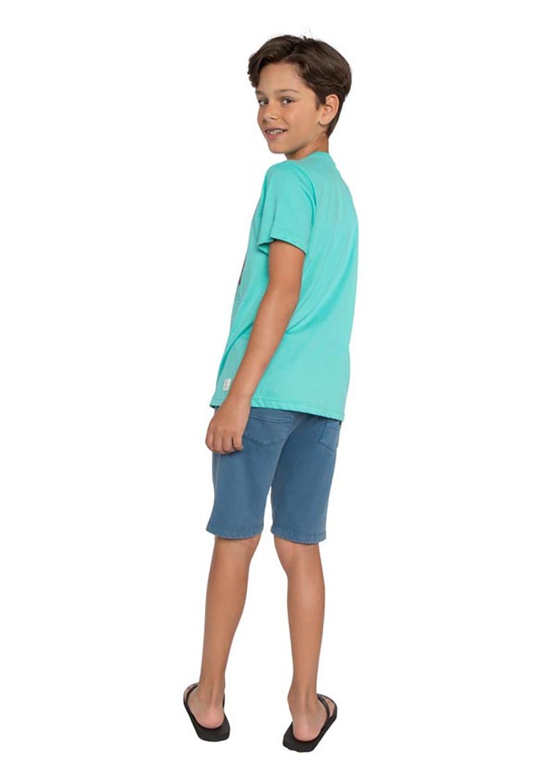 Turquoise katoenen T-shirt met korte mouwen, gecombineerd met blauwe denim shorts. Het kind staat zijwaarts, met zwarte slippers aan.