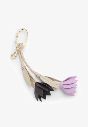 Sleutelhanger met gouden ring en beige leren bandjes waar twee bloembedels aan hangen, één zwart en één lavendel, elk met gelaagde bloemblaadjes en bladeren.