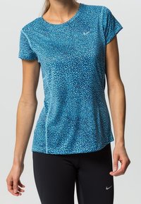 Blå kortärmad träningsskjorta med en strukturerad, mönstrad design. Innehåller subtilt Nike-logotyp och en vanlig passform. Slät tyg.