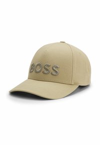 Beige cap with a curved brim and embroidered "BOSS" logo in grey. Fabric features a smooth texture and structured design for a fitted look.