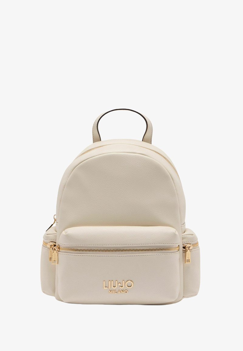 Zaino in pelle color crema con forma arrotondata, dettagli in metallo dorato e tasca con zip frontale. Presenta una maniglia superiore e spallacci regolabili.