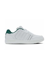 Adidași albi cu accent verde pe toc, design perforat pe lateral, talpă plată și șireturi. Materialul pare a fi piele sintetică netedă.