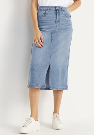 Light blue denim skirt with a straight silhouette, knee-length, front slit, five pockets, and belt loops, paired with white sneakers.