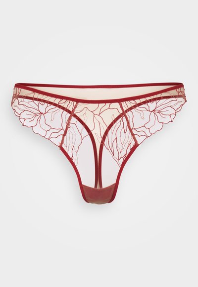 Thong rouge brodé mettant en avant des motifs floraux sur un tissu transparent, avec une taille lisse et de délicates bordures festonnées. Design léger.
