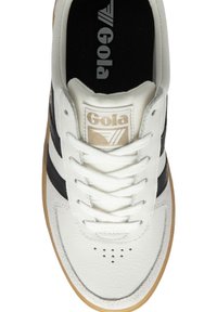Sneaker bianca in pelle con strisce nere, punta rotonda, suola in gomma e dettagli testurizzati. Etichetta del logo sulla linguetta. Lacci infilati attraverso i passanti.