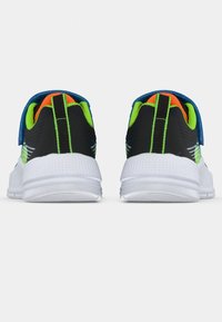 Színes sportcipők párja fehér talppal, fekete és neon zöld hátsó résszel, narancssárga belső béléssel és kék pántokkal, hátsó nézetből mutatva.