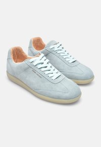 Light blue suede sneakers with a smooth finish, contrasting peach inner lining, flat laces, and a rubber sole with subtle texture.