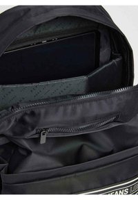 Mochila negra con un exterior de nailon liso y cremalleras. El interior presenta un compartimento acolchado y un forro con un patrón de logo repetido.