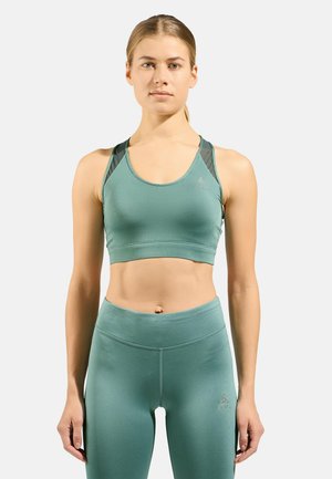 Teal sports bra and matching leggings made from smooth, stretchy fabric. Features a racerback design with mesh panels for breathability.