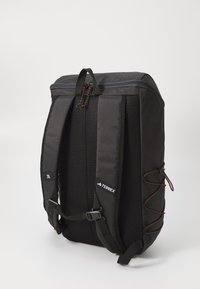 Black backpack made from durable fabric, featuring mesh panels, adjustable straps, a zip closure, and a bungee cord for extra storage.