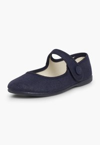 Zapato estilo Mary Jane en azul marino con tejido texturizado, punta redondeada y correa ajustable con un detalle de botón circular. Suela plana.