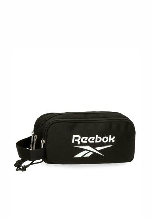 Bolsa negra con cremallera de Reebok con dos compartimentos y un asa lateral, con un logo blanco de Reebok en el frente.
