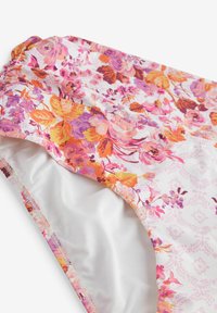 Ziedu bikini apakšdaļa ar baltu pamatu, rozā un oranžiem ziedu rakstiem, saplacinātām malām un gludu iekšējo oderi.