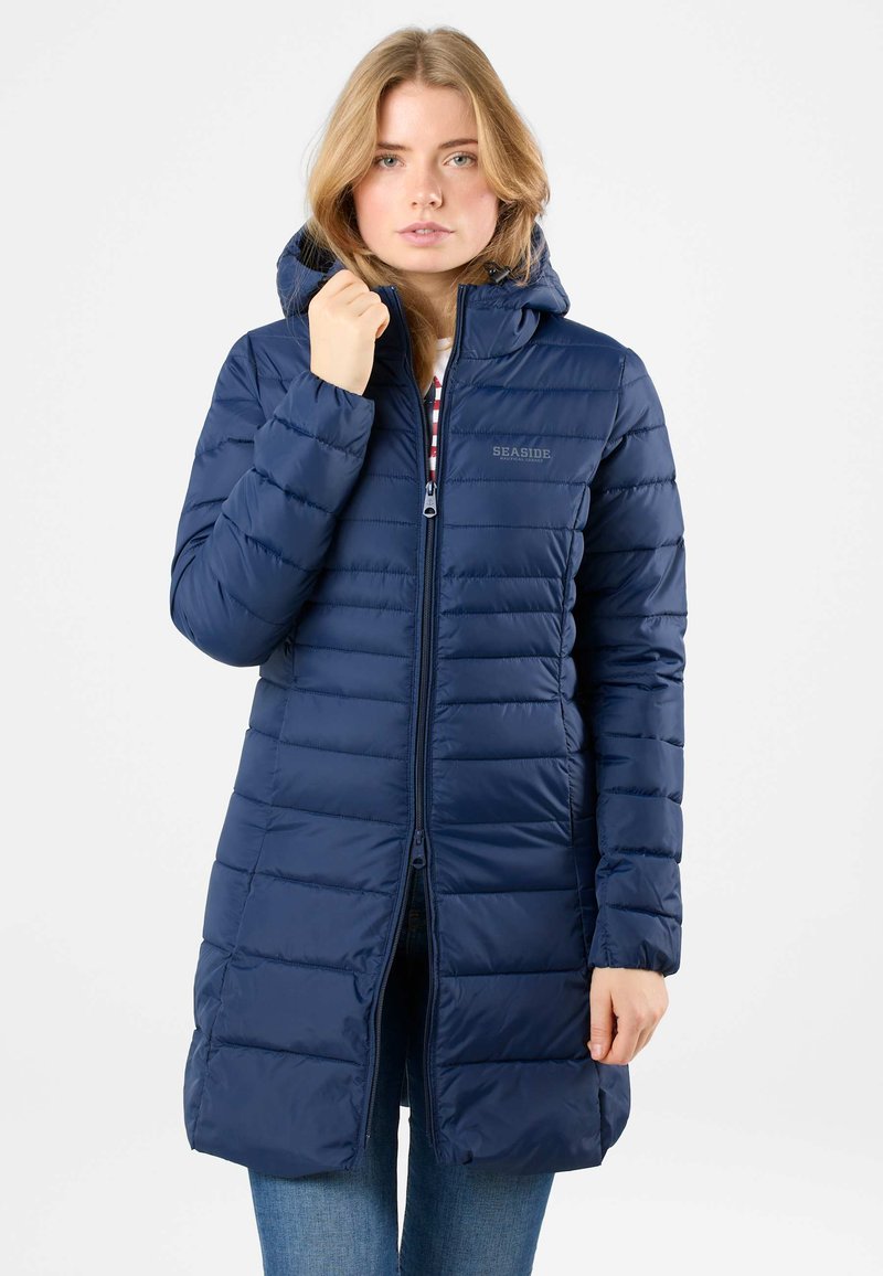 Parka imbottita blu navy con cappuccio, lunghezza lunga, chiusura con zip, design trapuntato e logo discreto sul petto.
