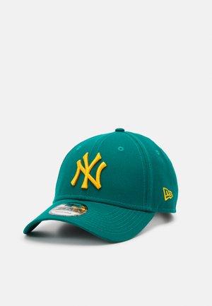 Teal baseball cap with yellow embroidered "NY" logo. Features a curved brim and textured fabric. Includes a logo tag on the side.