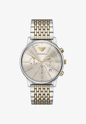 Silberne und goldene Edelstahluhr mit rundem, beigem Zifferblatt, drei Hilfszifferblättern und strukturierter Oberfläche. Oben befindet sich ein Adler-Logo.