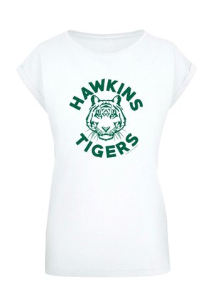 Fehér póló, rövid felgöngyölített ujjal, zöld tigrisarc grafikával és a "HAWKINS TIGERS" felirattal kör alakban.