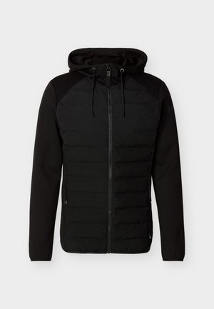 Svart hettejakke med quilteforpanel, glidelåslukking, snorer på hette og lange ensfargede ermer mot en ensfarget bakgrunn.