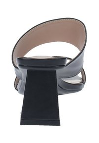 Sandaletta nera con tacco alto e largo, aperta sul retro e con due fasce sottili sulla parte superiore del piede. Fodera interna liscia.