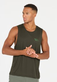 Donkergroen mouwloos sporttanktop met een gestructureerde stof. Voorzien van kleine groene strepen op de borst. Glad decolleté, geen zichtbare logo's.