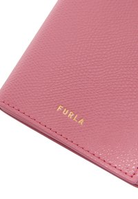Portafoglio in pelle testurizzata rosa con motivo impresso e logo dorato "FURLA" in evidenza. I bordi cuciti valorizzano i dettagli del design.