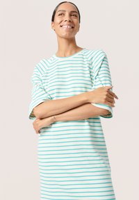 Rochie în dungi albă și turquoise deschis, cu o croială lejeră, mâneci scurte și decolteu rotund. Textură de țesătură moale.
