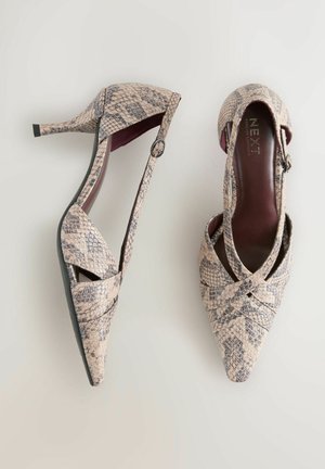 Chaussures à talons avec un bout pointu, fabriquées en matière beige texturée avec un motif peau de serpent. Détails de bordure noire et bride à la cheville inclus.