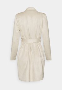 Beżowy płaszcz z zamszu z paskiem w talii, długimi rękawami i gładką teksturą. Posiada klasyczny kołnierz oraz dopasowany, zorganizowany krój.