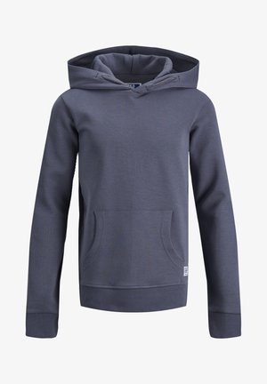 Szara bluzka z kapturem wykonana z miękkiego materiału, zestawiona z niebieskimi, przetartymi, obcisłymi dżinsami oraz czarnymi, wysokimi trampkami z białymi akcentami.