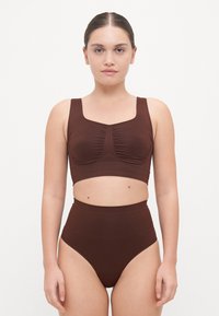 Brown two-piece swimwear set featuring a sleeveless, fitted top with ruching and high-waisted bottoms, made from smooth, stretchy fabric.