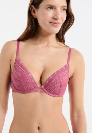Rosa Spitzen-BH mit tiefem Ausschnitt, verstellbaren Trägern und geometrischen Mustern mit strukturierten Akzenten. Weicher, zarter Stoff.