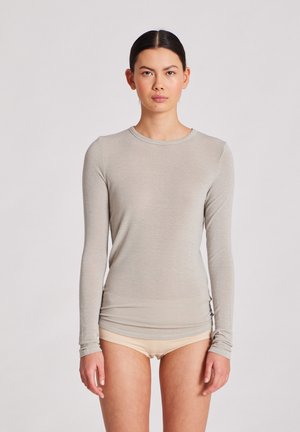 Chemise à manches longues gris clair en tissu léger et doux, avec un col rond et une coupe ajustée. Manches sans couture avec une texture subtile.