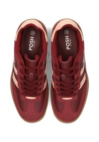 Rote Sneaker zeichnen sich durch eine Mischung aus strukturierten Materialien aus, darunter eine glatte Zehenkappe, zarte rosa Akzente und dicke Schnürsenkel. Gummisohle mit niedrigem Profil.