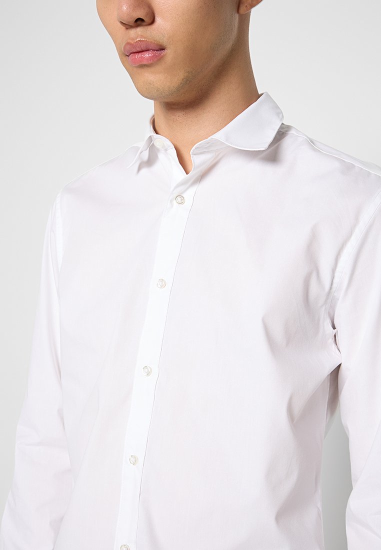 Witte langslavende shirt in een lichtgewicht stof, met een knoopsluiting aan de voorkant, een klassieke kraag en subtiele textuur.