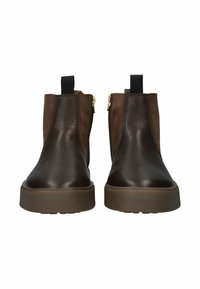Hnědé kožené kotníkové boty s hladkou texturou, bočními zipy a černými elastickými detaily. Mají výšku díky klínové podrážce.