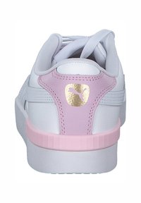 Sneaker bianco con finitura in pelle liscia, dotato di un tallone rosa e un accento in logo dorato. Forma arrotondata con suola in gomma testurizzata.