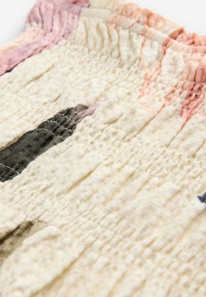 Strukturiertes, helles Creme-Stoff mit subtilen Falten; zeigt abstrakte dunkle und pastellfarbene Formen. Weiche und leicht zerknitterte Oberfläche.