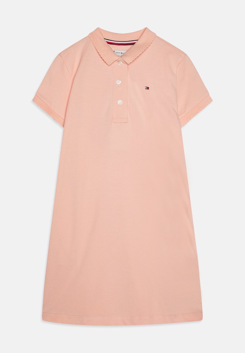 Šviesiai rožinė medvilninė polo su švelniais krašteliais, trumpomis rankovėmis ir trimis mygtukais. Ant krūtinės yra mažas logotipas.