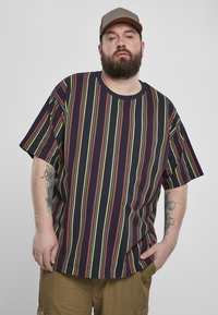 T-shirt casual bleu marine à manches courtes avec des rayures verticales rouges et vertes, offrant une coupe ample et un col rond. Tissu en coton.